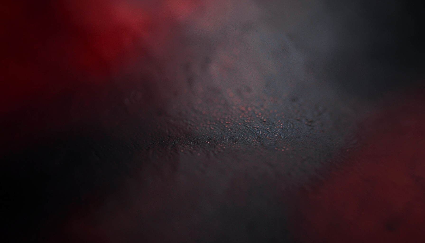 Dark abstract surface with subtle metallic reflections and a deep charcoal gradient